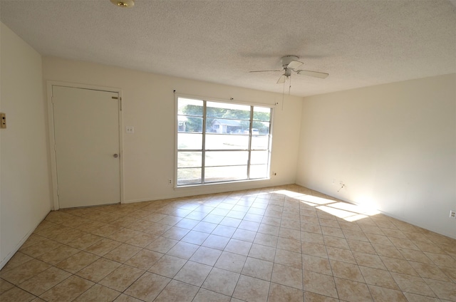 tiled spare room featuring a textured ceiling and ceiling fan