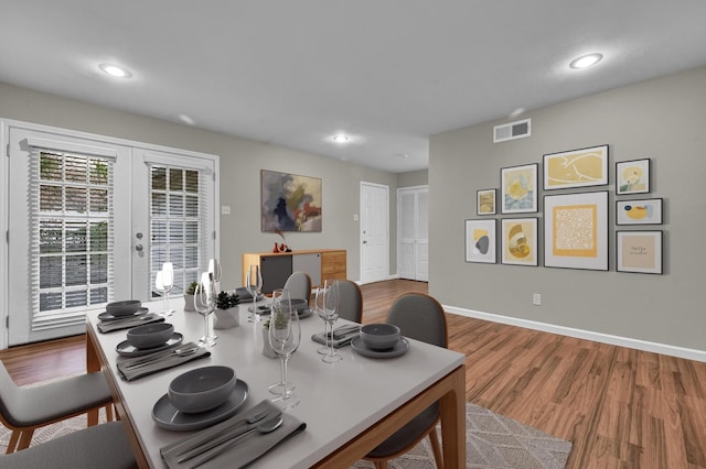 dining space with french doors and hardwood / wood-style flooring