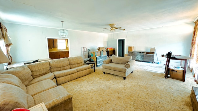 living room featuring ornamental molding, carpet, and ceiling fan with notable chandelier