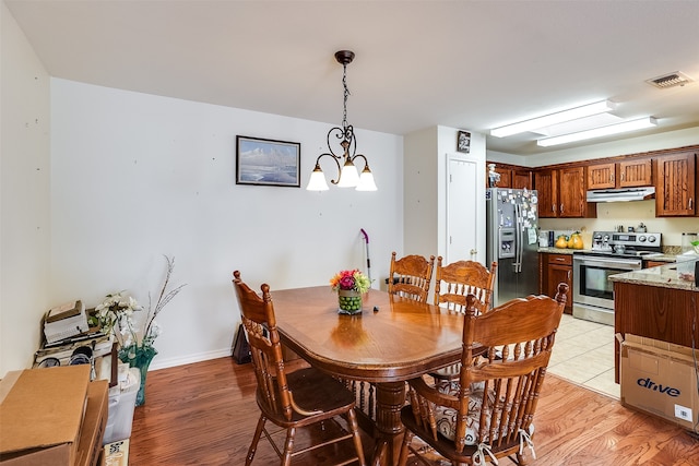 dining room featuring light hardwood / wood-style flooring and a chandelier