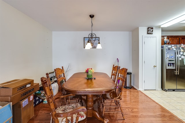 dining space with light hardwood / wood-style flooring and a chandelier