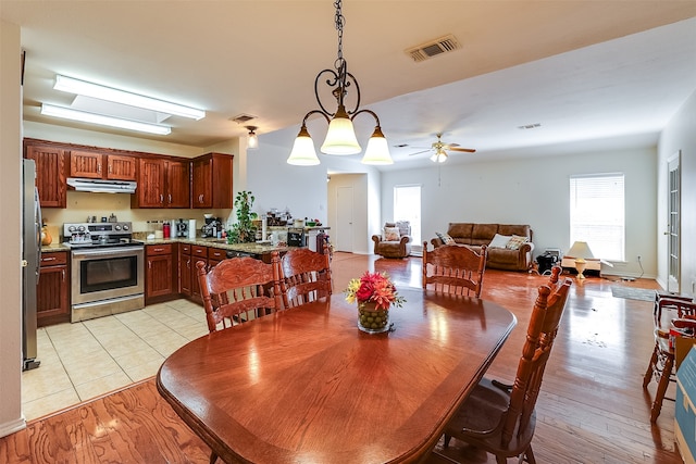 dining space with light wood-type flooring, a healthy amount of sunlight, and ceiling fan