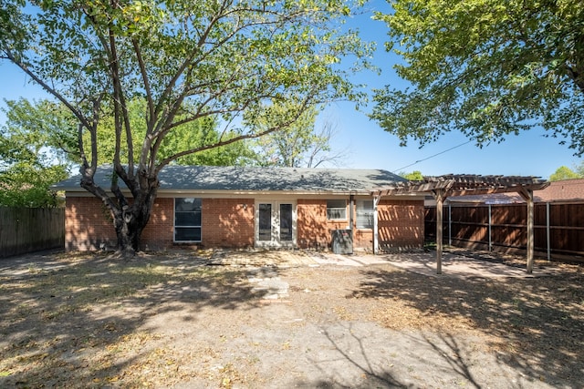 rear view of property featuring a pergola