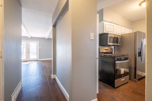 kitchen featuring white cabinets, dark hardwood / wood-style flooring, beamed ceiling, french doors, and stainless steel appliances