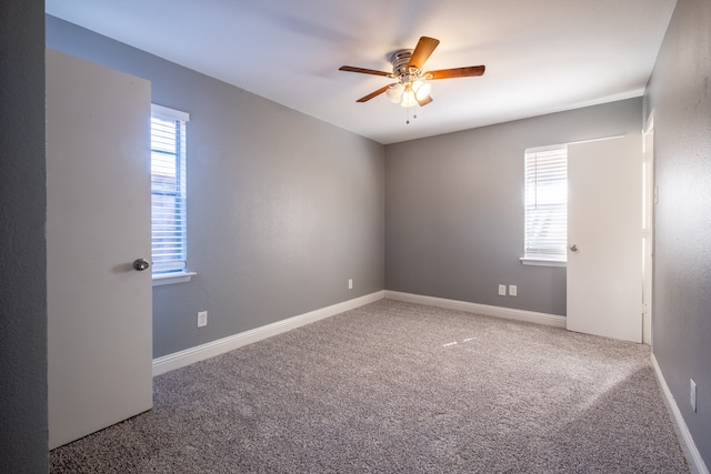 spare room featuring ceiling fan, carpet flooring, and plenty of natural light