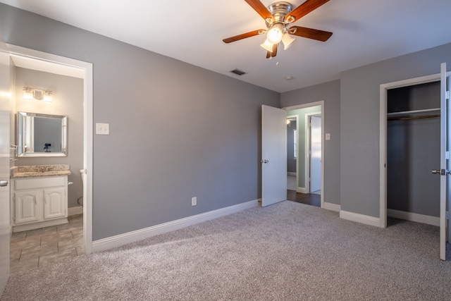 unfurnished bedroom featuring light carpet, ensuite bathroom, a closet, and ceiling fan