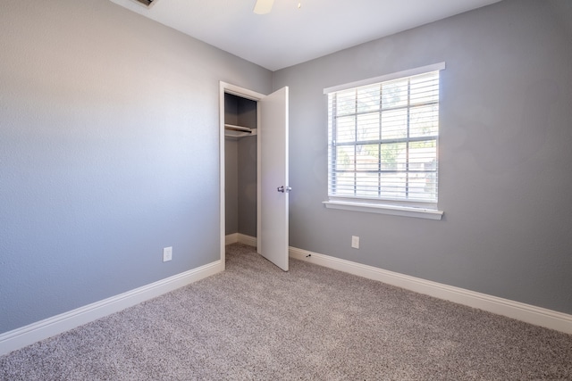 unfurnished bedroom featuring carpet flooring, a closet, and ceiling fan