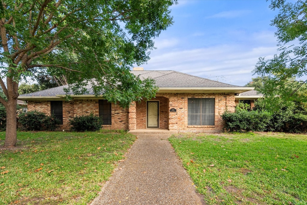 ranch-style home with a front lawn