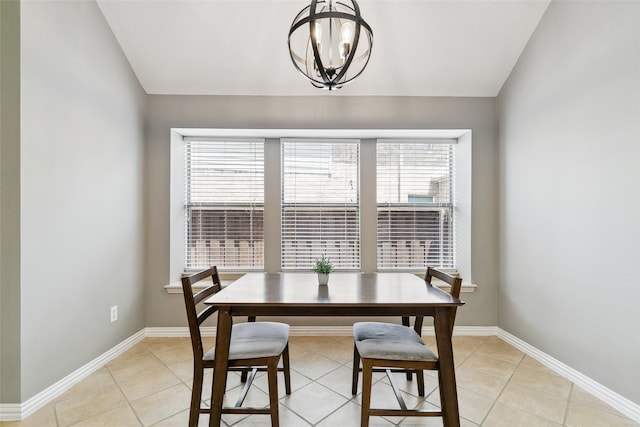 dining area with lofted ceiling, a healthy amount of sunlight, light tile patterned flooring, and a notable chandelier