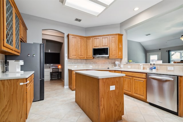 kitchen with tasteful backsplash, ceiling fan, a kitchen island, vaulted ceiling, and dishwasher