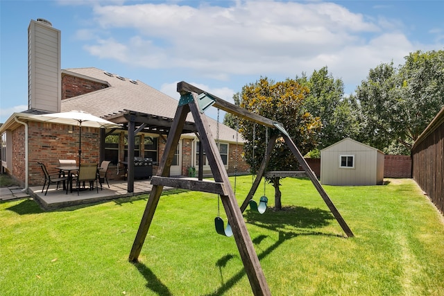 view of playground with a yard, a shed, a patio area, and a pergola