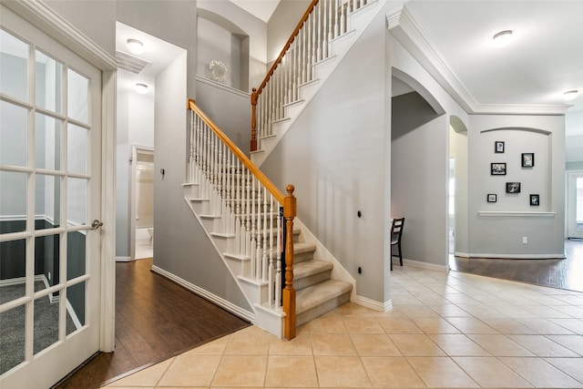 stairs with crown molding, a wealth of natural light, and hardwood / wood-style floors