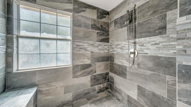 bathroom featuring a wealth of natural light and tiled shower