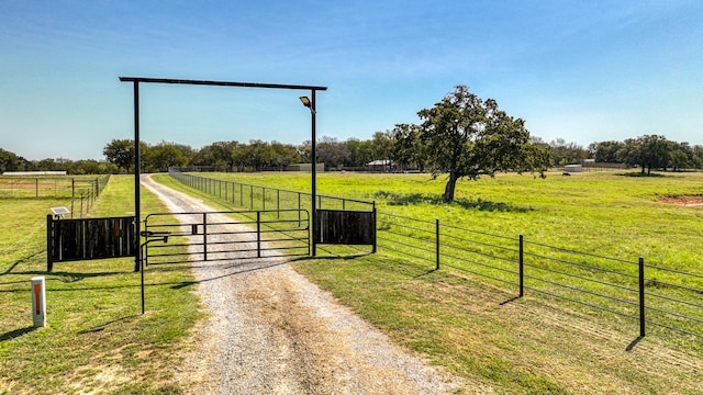 view of gate featuring a rural view and a yard