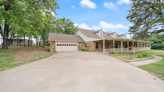 view of front of property with covered porch, a front yard, and a garage