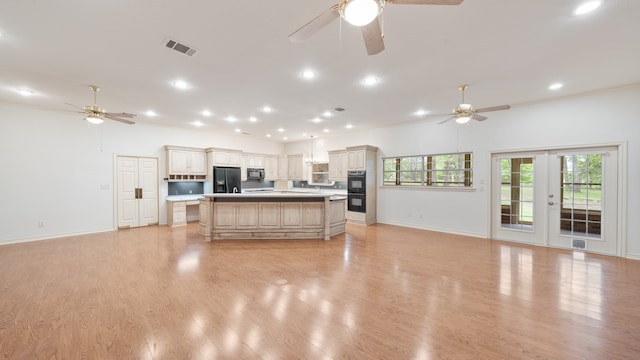 kitchen with light hardwood / wood-style flooring, french doors, black appliances, and a kitchen island