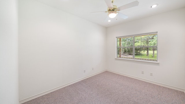 carpeted spare room with ceiling fan