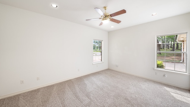 unfurnished room with a wealth of natural light, carpet, and ceiling fan