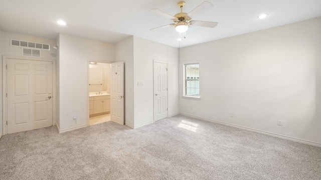 unfurnished bedroom featuring a closet, ceiling fan, sink, and light colored carpet