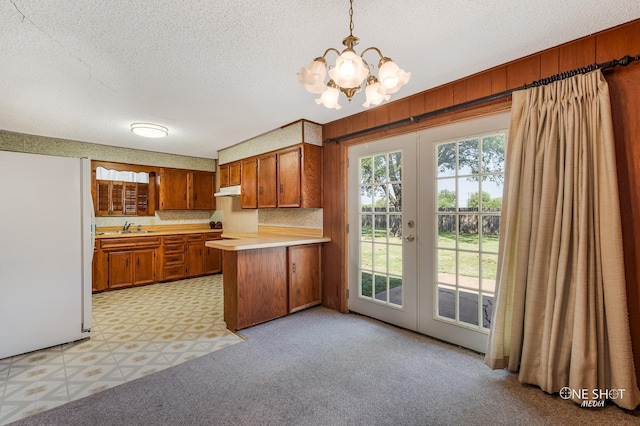 kitchen featuring sink, french doors, hanging light fixtures, white refrigerator, and kitchen peninsula