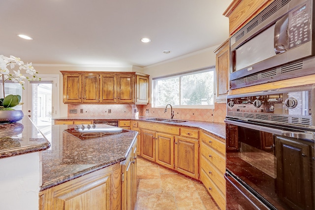 kitchen with black appliances, crown molding, dark stone counters, decorative backsplash, and sink