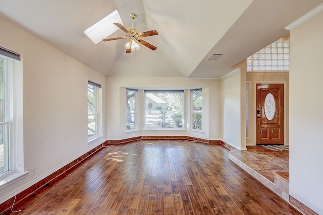 unfurnished living room featuring hardwood / wood-style floors, ceiling fan, a skylight, and high vaulted ceiling