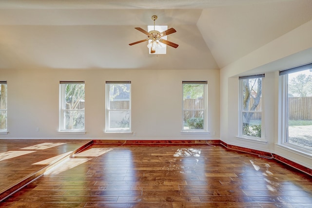 spare room featuring dark wood-type flooring, vaulted ceiling, and ceiling fan