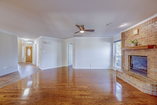 unfurnished living room with a fireplace, wood-type flooring, ceiling fan, and crown molding