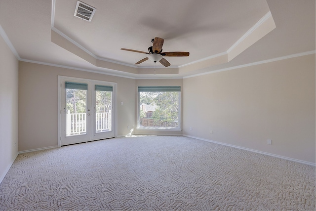 empty room with ceiling fan, light carpet, crown molding, and a tray ceiling