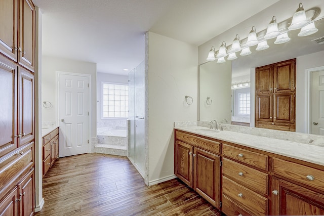 bathroom with hardwood / wood-style flooring, vanity, and shower with separate bathtub