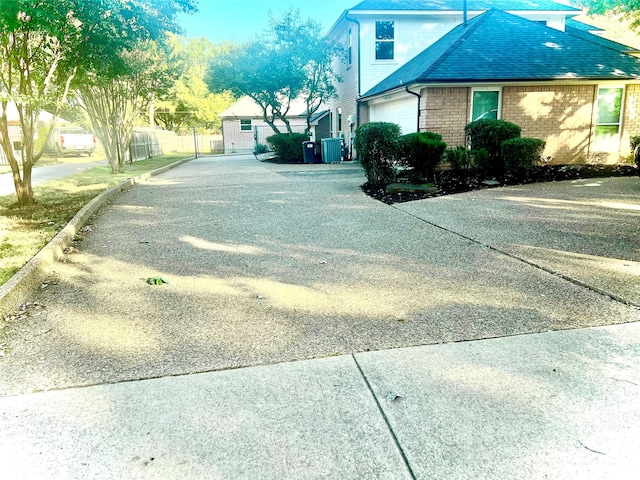 view of side of property featuring a garage and cooling unit