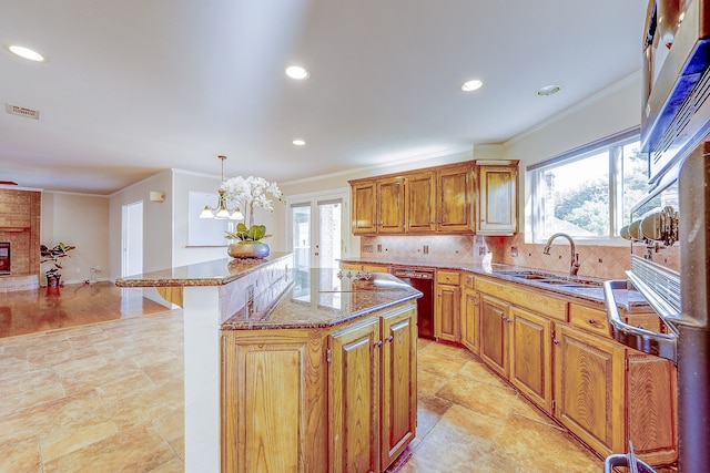 kitchen featuring a kitchen island, pendant lighting, sink, and plenty of natural light