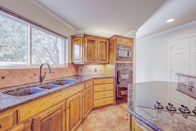 kitchen featuring dark stone counters, built in microwave, sink, and backsplash