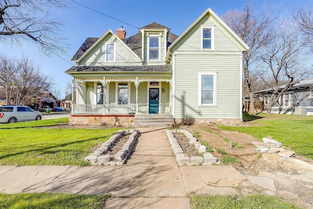 victorian house featuring a porch and a front lawn