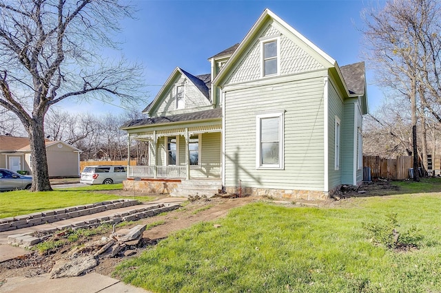 view of front of home with central air condition unit, a porch, and a front lawn