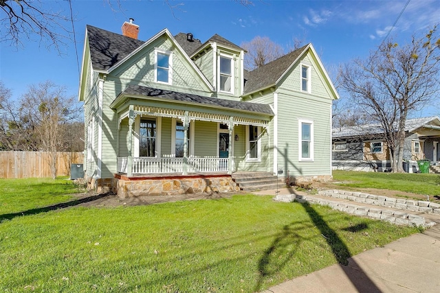 victorian-style house featuring a front lawn and covered porch