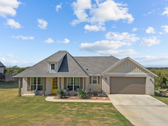 view of front of property with a porch, a garage, and a front lawn