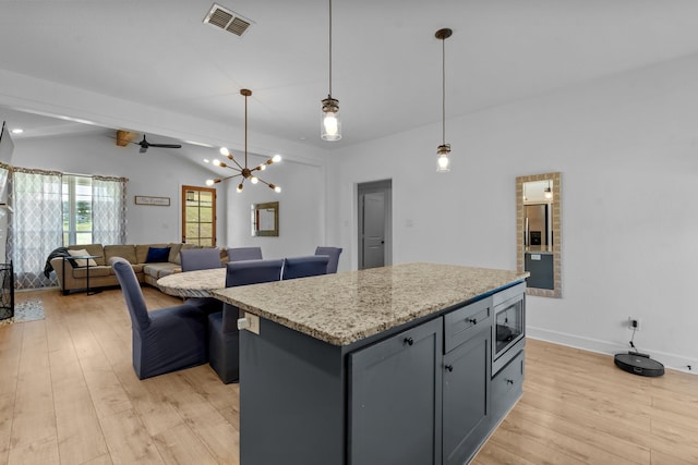 kitchen featuring vaulted ceiling with beams, light hardwood / wood-style floors, pendant lighting, a kitchen island, and appliances with stainless steel finishes