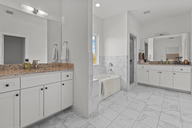 bathroom with shower with separate bathtub, vanity, and tile walls