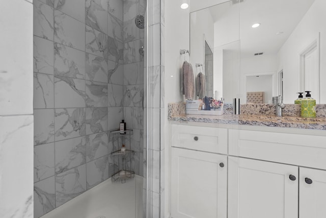 bathroom with vanity and tiled shower