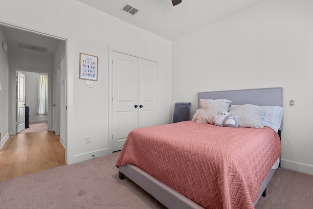 bedroom with ceiling fan, a closet, and light hardwood / wood-style floors