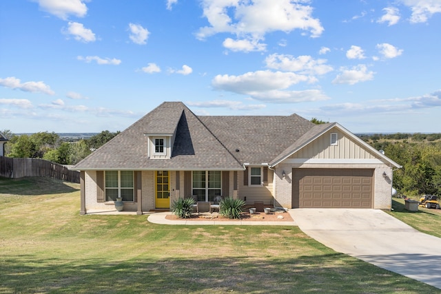 view of front of house featuring covered porch, a garage, and a front yard