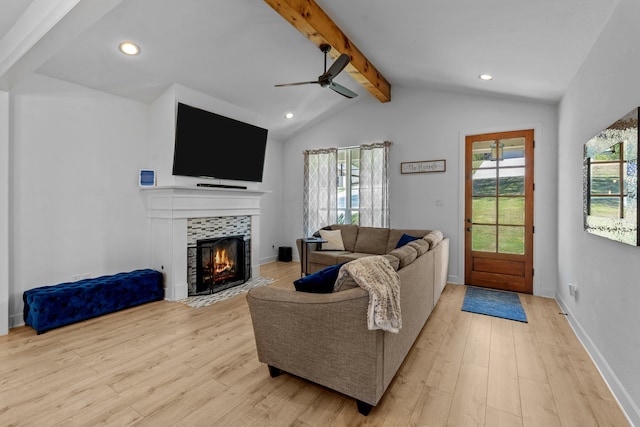 living room with ceiling fan, a fireplace, a healthy amount of sunlight, and light wood-type flooring