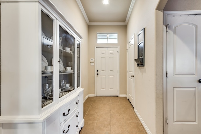 doorway to outside with crown molding and light tile patterned floors