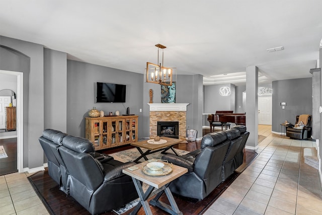 tiled living room with a notable chandelier and a fireplace