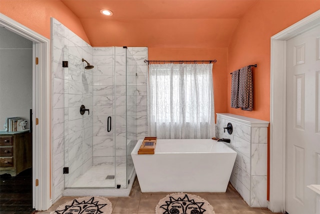 bathroom with independent shower and bath, vaulted ceiling, and tile patterned floors