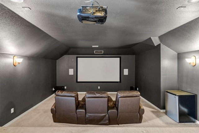 carpeted home theater with a textured ceiling and vaulted ceiling