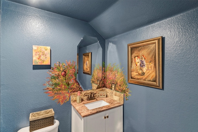 bathroom with vanity, vaulted ceiling, and toilet