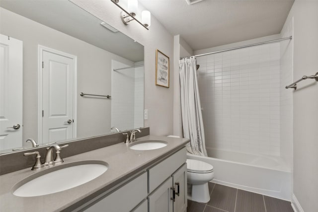 full bathroom with vanity, toilet, shower / bath combo with shower curtain, and a textured ceiling