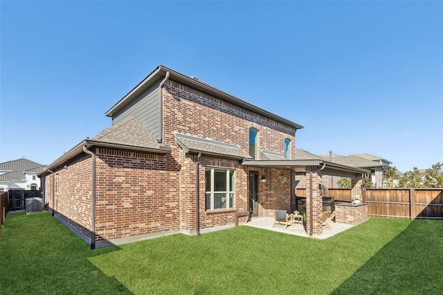 rear view of house featuring a yard and a patio